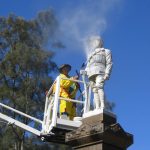 A cemetery restoration expert cleaning a headstone in Wollongong